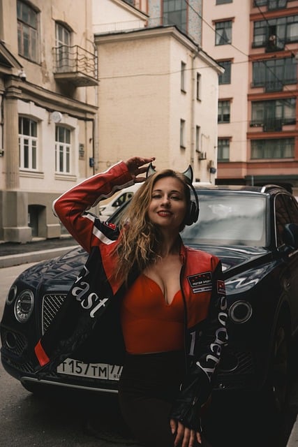 Entrepreneur posing confidently next to a sophisticated black car, representing a smart business investment through Rev Ride.